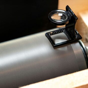 Close-up van een keramische wals met een vergrootglas om de oppervlaktekwaliteit te inspecteren.